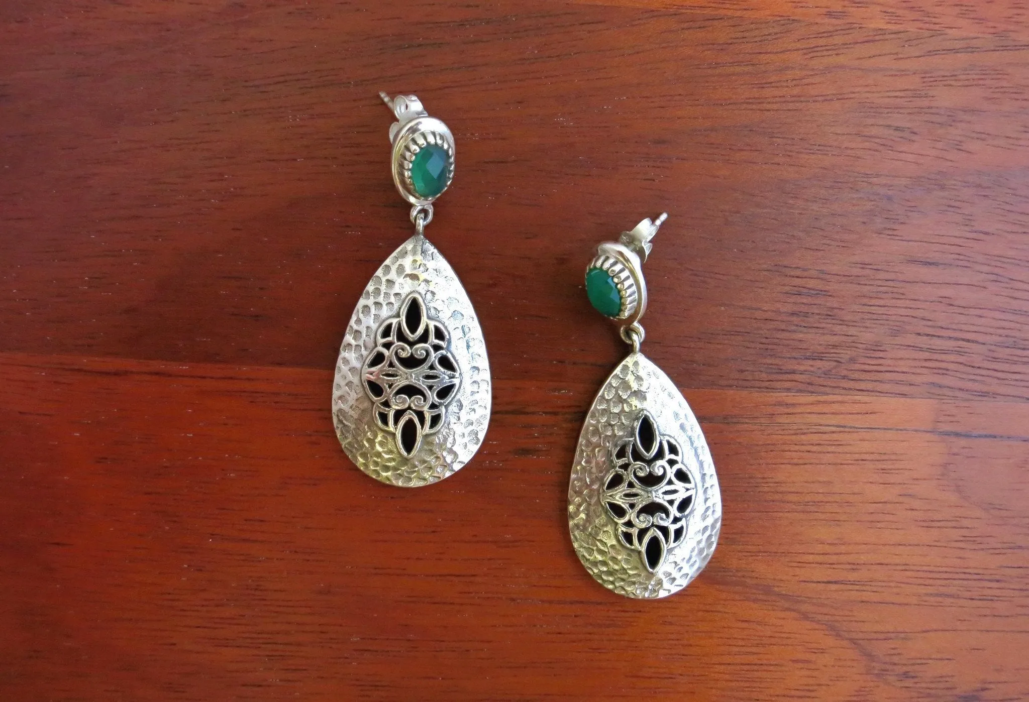 Exquisite, jali work and hammer finish earrings accented with green stone